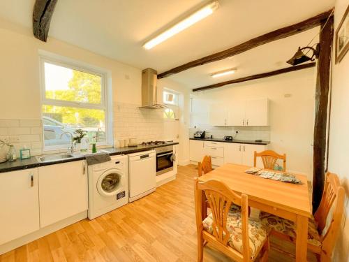 a kitchen with a wooden table and a dining room at 3 Bedroom House by Brookland Stays Serviced Accommodation Short Lets Leeds in Yeadon