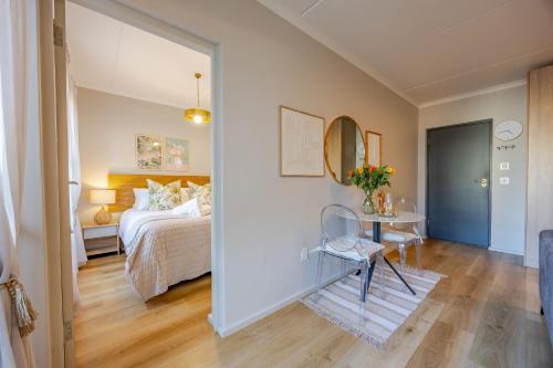 un dormitorio con una cama y una mesa en Modern 2 bed, 2 bath- Blouberg, en Bloubergstrand