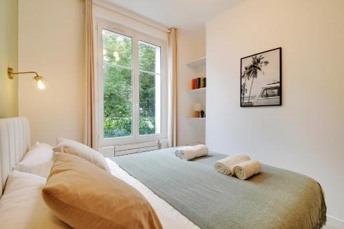 une chambre avec un lit avec deux oreillers dessus dans l'établissement Calm Square Flat, à Boulogne-Billancourt