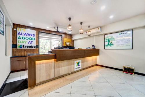a waiting room with a reception desk in a restaurant at Treebo Pratham Inn, Manipal in Udupi