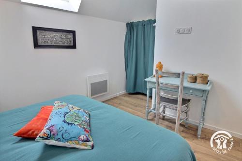 a bedroom with a bed and a table and a chair at Ty bara in Sainte-Hélène