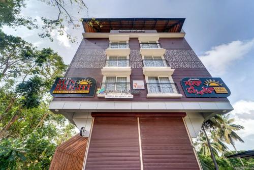 a tall building with windows on top of it at Treebo Pratham Inn, Manipal in Udupi