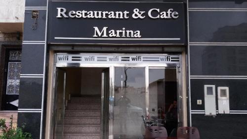 a sign for a restaurant and cafe in front of a building at Hôtel Marina in Tetouan