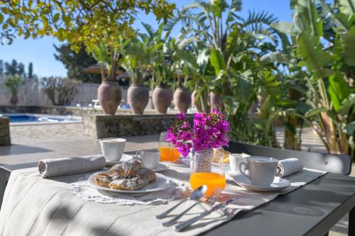 a table with a plate of food and flowers on it at Villa Felicia in Noto