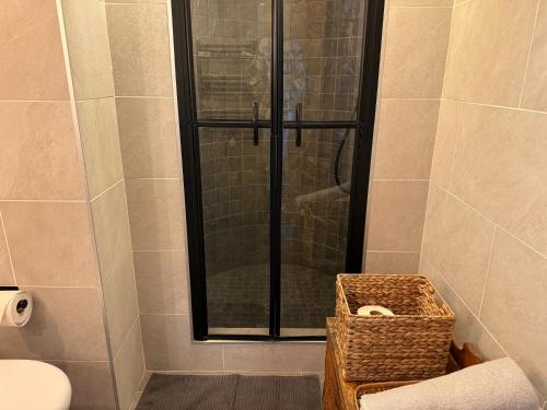 a bathroom with a shower with a toilet and a basket at Verbier 2 bedrooms apartment- Scenic view - 6 Pax in Verbier