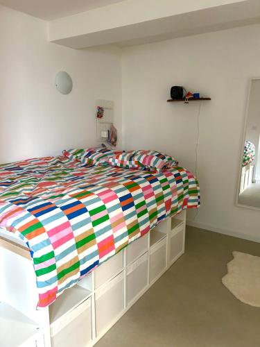 une chambre avec un lit avec une couette colorée dans l'établissement T2 RÉNOVÉ avec TERRASSE en HYPER CENTRE de Dijon, à Dijon