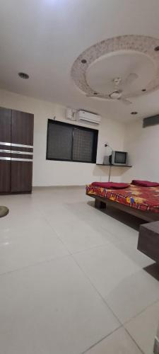 a white room with a bed in the middle of it at Hotel Poonam Lodge in Ahmadnagar