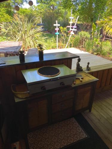 a wooden table with a stove on a deck at Villa piscine chauffée & spa sur le Bassin d Arcachon - proche plage et océan in Lanton