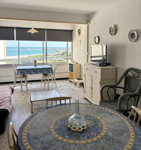 - un salon avec une table et une chambre avec vue dans l'établissement Idéal pour vos vacances face à la mer 4PSA47G2, au Barcarès