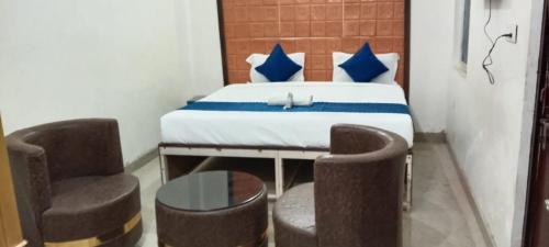 a room with a bed with two chairs and a table at HOTEL SANA ! - A Best Budget Guest House And Banquet Hall In Lucknow in Lucknow