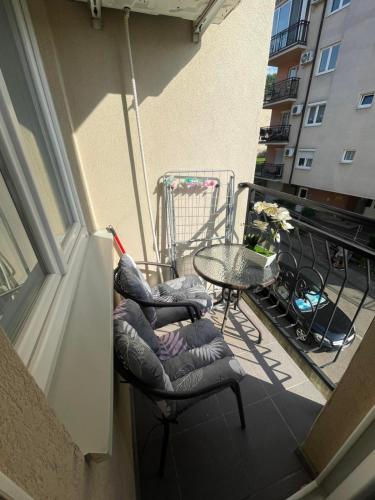 balcón con silla y mesa en Apartman 14, en Banja Koviljača