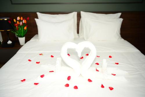 a couple of white hearts sitting on a bed at Ocean Park Homestay in HÆ°ng YÃªn