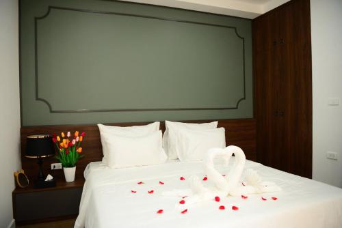 a bed with two white swans and hearts on it at Ocean Park Homestay in HÆ°ng YÃªn