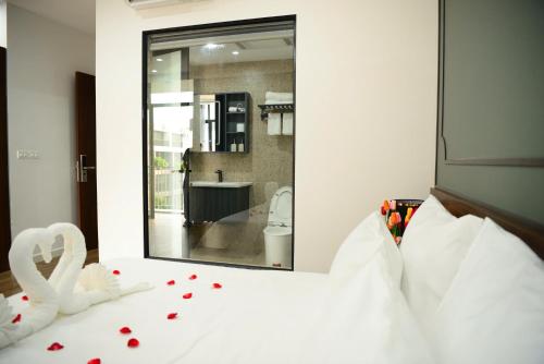 a bedroom with a white bed with a mirror at Ocean Park Homestay in HÆ°ng YÃªn