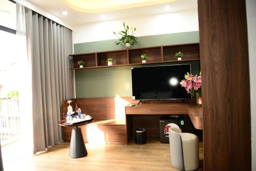 a living room with a flat screen tv on a wall at Ocean Park Homestay in HÆ°ng YÃªn