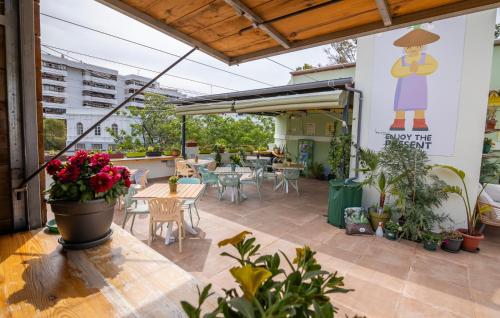 a patio with tables and chairs and a sign on the wall at GrowersGo Boutique Huelva in Huelva