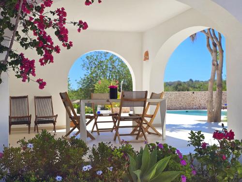 taras ze stołem, krzesłami i kwiatami w obiekcie INIBIZA VILLAS - Villa Bello w mieście San Antonio