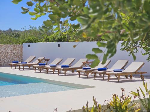 szereg leżaków przy basenie w obiekcie INIBIZA VILLAS - Villa Bello w mieście San Antonio