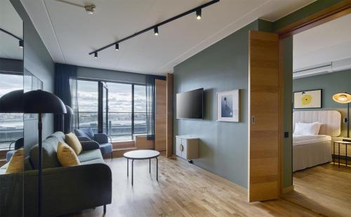 a living room with a couch and a bed at Scandic Alvik in Stockholm