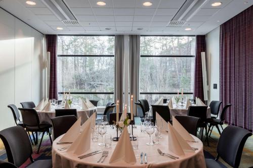 a conference room with tables and chairs and large windows at Scandic Alvik in Stockholm