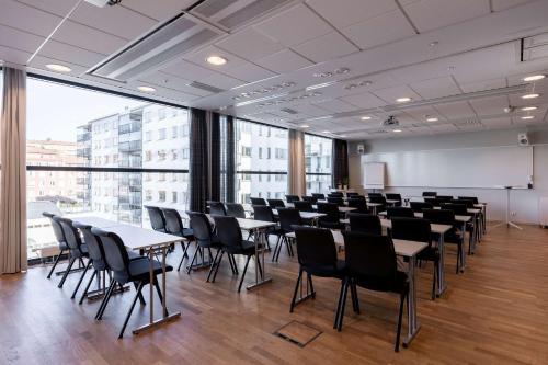 a conference room with tables and chairs and a whiteboard at Scandic Alvik in Stockholm