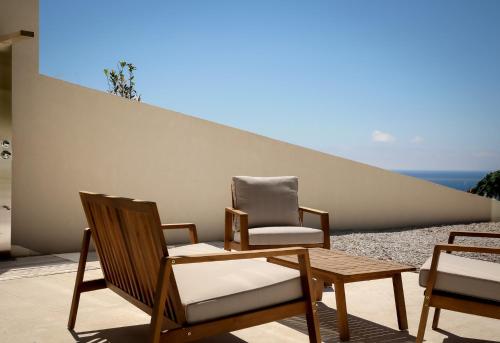 two chairs and a table on a patio at Scirocco Luxury Villas & Suites in Vasiliki