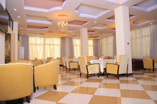 a dining room with tables and chairs and a chandelier at Sunland International Hotel in Kolobo