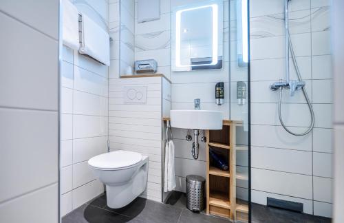 a bathroom with a toilet and a sink at Hotel Villa Sulmana in Neckarsulm