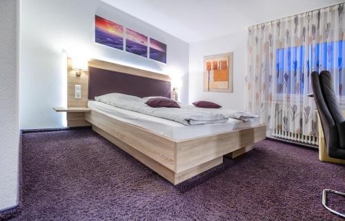 a bedroom with a large bed in a room at Hotel Villa Sulmana in Neckarsulm