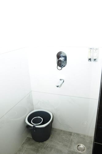 a bathroom with a black toilet in a stall at Vgrand in Ooty
