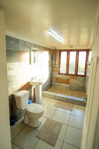 ein Badezimmer mit Toilette, Waschbecken und Dusche in der Unterkunft Sunset Lodge in Miramar