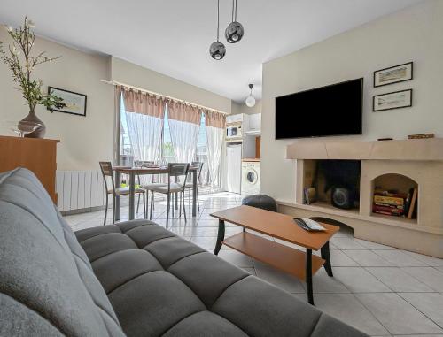 a living room with a couch and a fireplace at La Pause Cabourgeaise in Cabourg