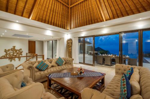 a living room with couches and a table at Karang Saujana in Uluwatu