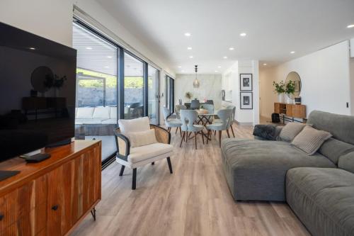 a living room with a couch and a dining room at Casa Pura Vida - Heated Pool and Sea View in Ponta Delgada