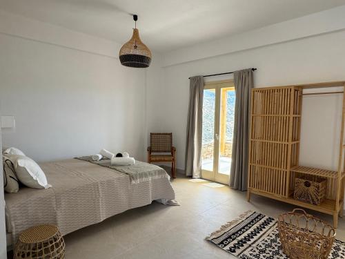 a bedroom with a bed and a window at Almyriki in Mylopotas