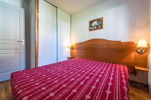 une chambre avec un lit avec une couverture rouge dans l'établissement Apartment for 6 to 8 people in Albiez-Montrond 5-min walk from the slopes, à Albiez-Montrond
