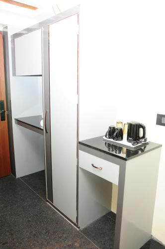 a kitchen with a white refrigerator and a counter at Vgrand in Ooty