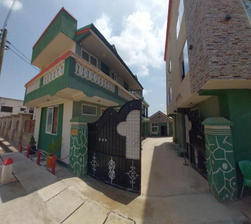 a house with a gate in front of a building at chikays plaza in Trofwi