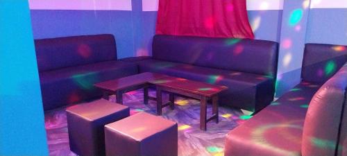 a living room with a couch and a table with stools at chikays plaza in Trofwi