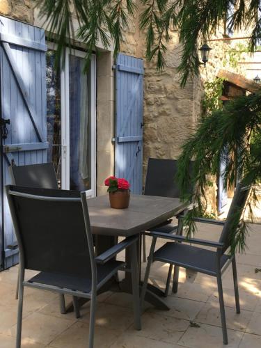 a wooden table and chairs on a patio at Le Mazet d’Eden avec son jardin privé in Vagnas