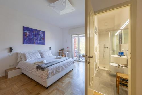 a white bedroom with a bed and a bathroom at Blue Dream in Ispra
