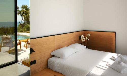 a bedroom with a bed and a view of a patio at Scirocco Luxury Villas & Suites in Vasiliki