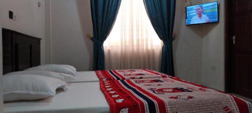 a bedroom with a bed with a blanket on it at chikays plaza in Trofwi