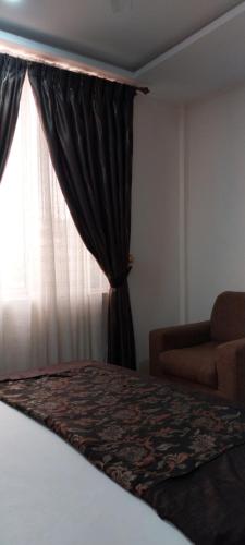 a bedroom with a bed and a window with a curtain at chikays plaza in Trofwi