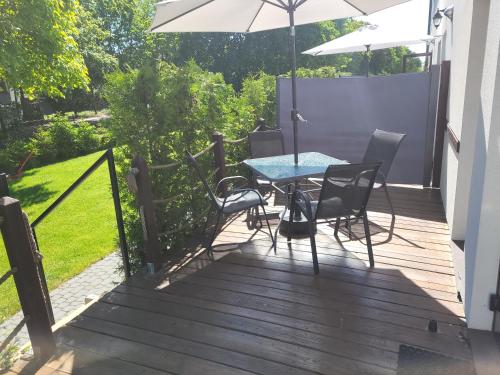 a deck with a table and chairs and an umbrella at Pod Starym Klonem in Przybrodzin