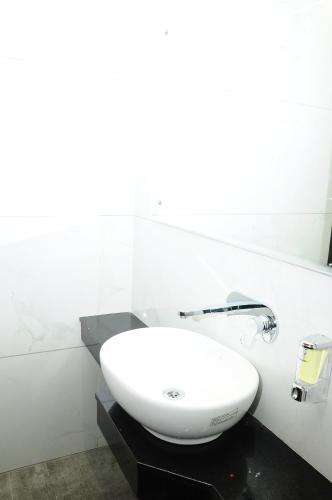 a bathroom with a white sink on a black counter at Vgrand in Ooty