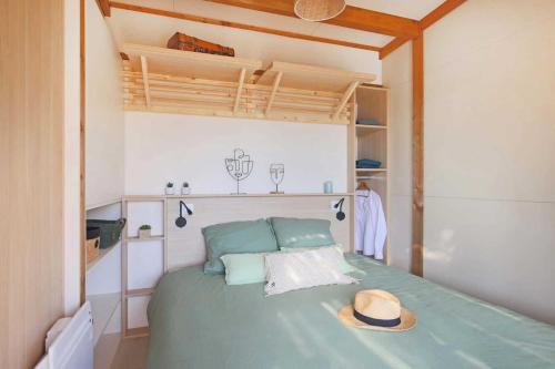 a bedroom with a bed with a hat on it at Camping - Piscine - ccbbdag in Vic-sur-Cère