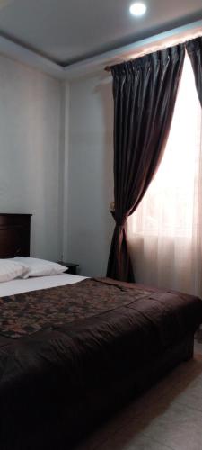 a bedroom with a bed and a window at chikays plaza in Trofwi