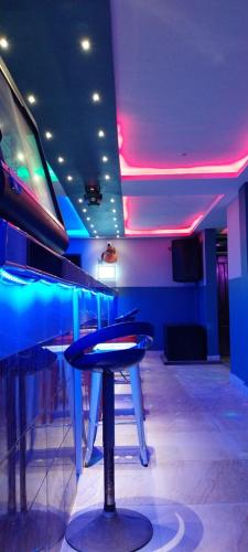 a room with a bar with blue and purple lights at chikays plaza in Trofwi