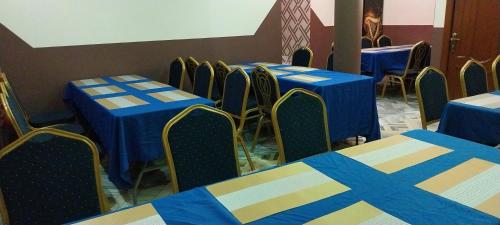 a row of tables and chairs with blue and yellow table cloth at chikays plaza in Trofwi